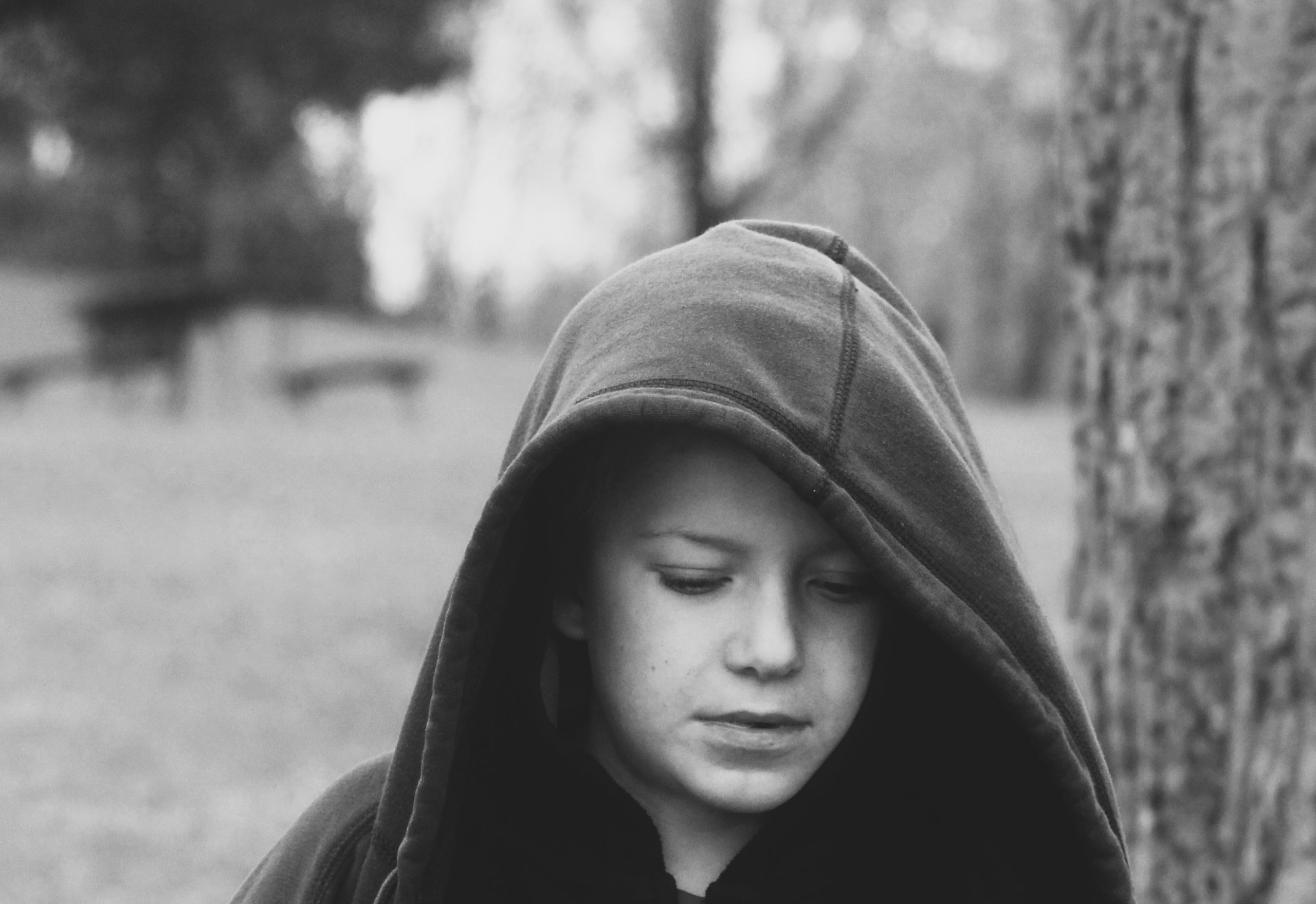 bw tom A young child with a hoodie over his head in black and white
